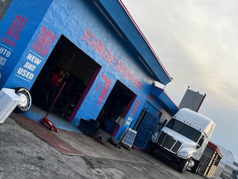 Florida Truck Tires shop, painted blue, with a semi-truck parked outside