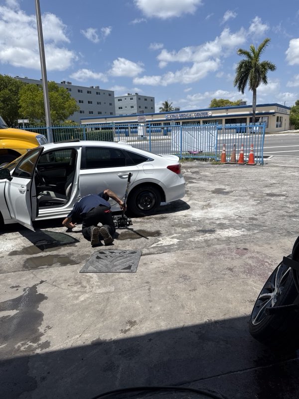 Technician repairing a tire on a sedan